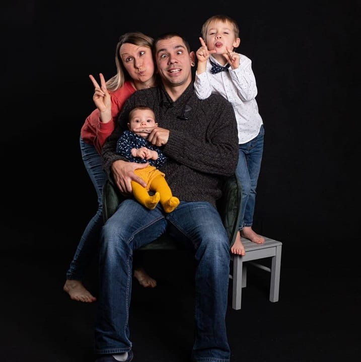 Une famille posant avec des expressions amusantes lors d'une séance photo en studio, capturée par Amandine Donato, photographe professionnelle.