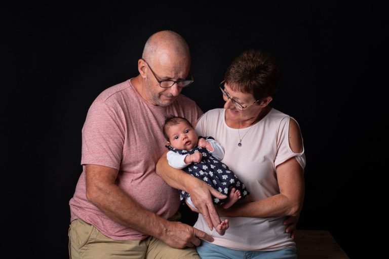 Grand-parents tenant leur petite-fille nouveau-née - Photo par Amandine Donato, photographe à Josselin